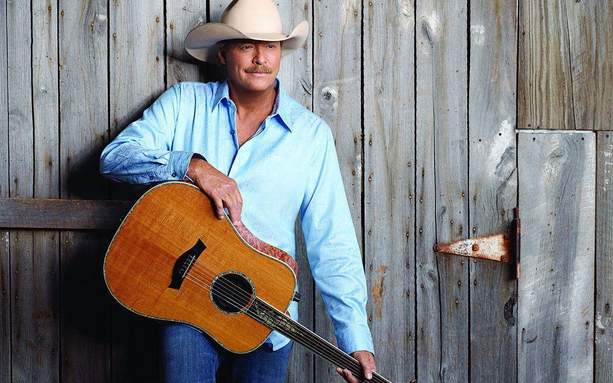 Alan Jackson Standing Against Wooden Wall Wallpaper