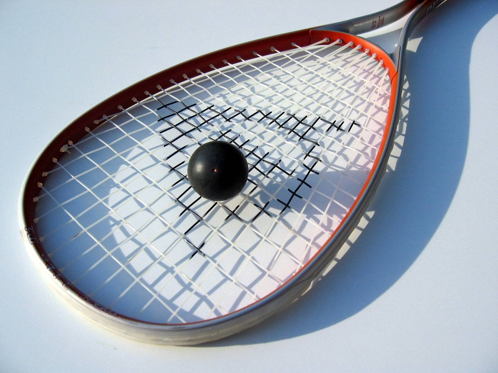 Black Hollow Ball On Squash Racket Wallpaper