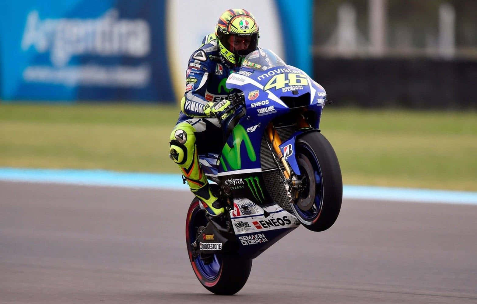 Caption: Thrilling Vr46 Yamaha Wheelie Stunt On The Racetrack. Wallpaper