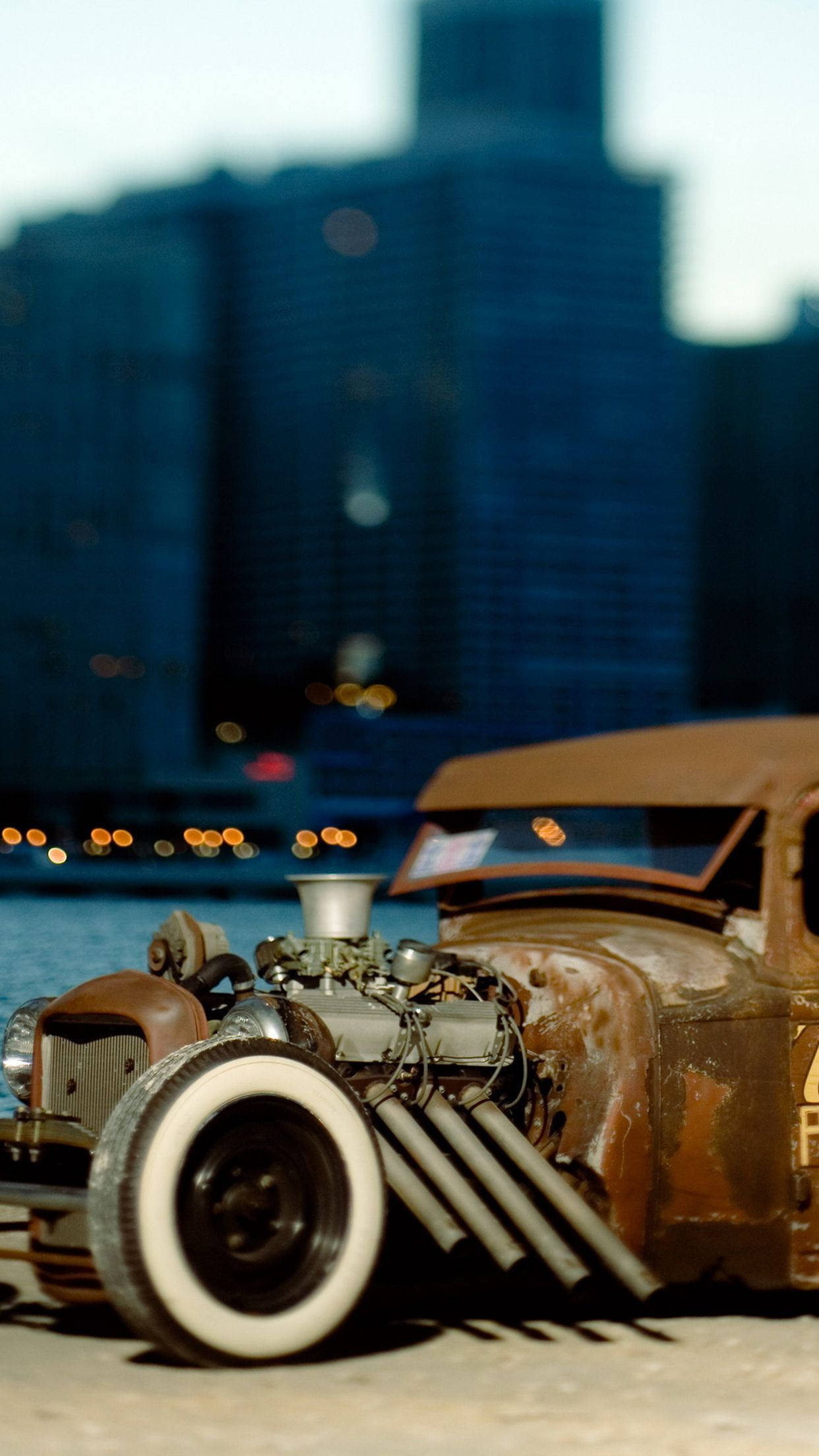 Caption: Vintage Rat Rod Car In City Sunset Wallpaper