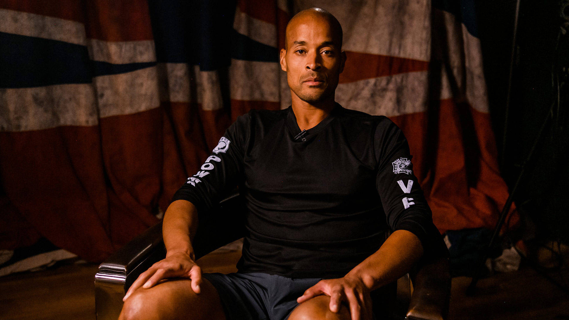 David Goggins Posing In Chair Wallpaper