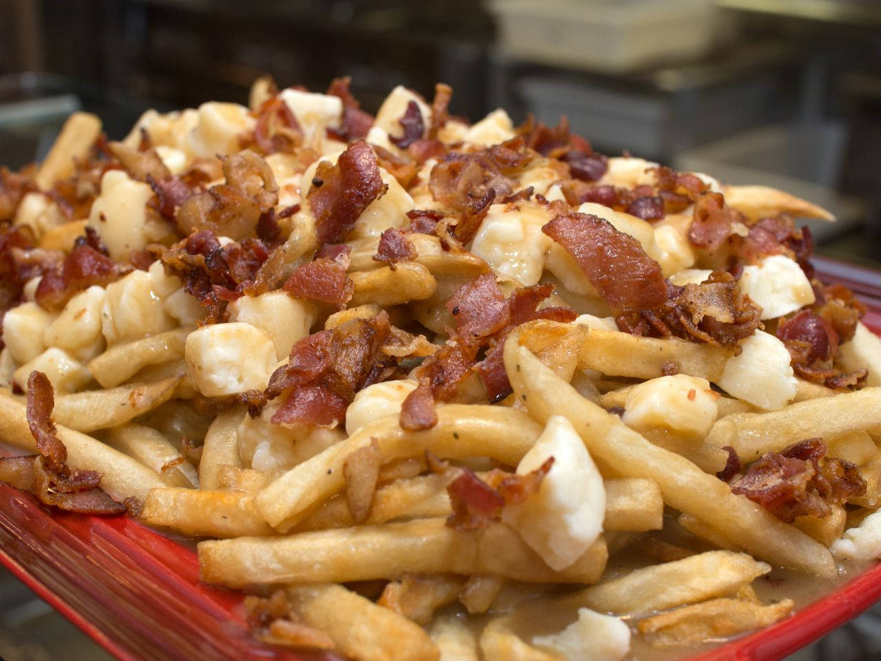 Delicious Poutine With Cheese Curds And Bacon Bits Wallpaper