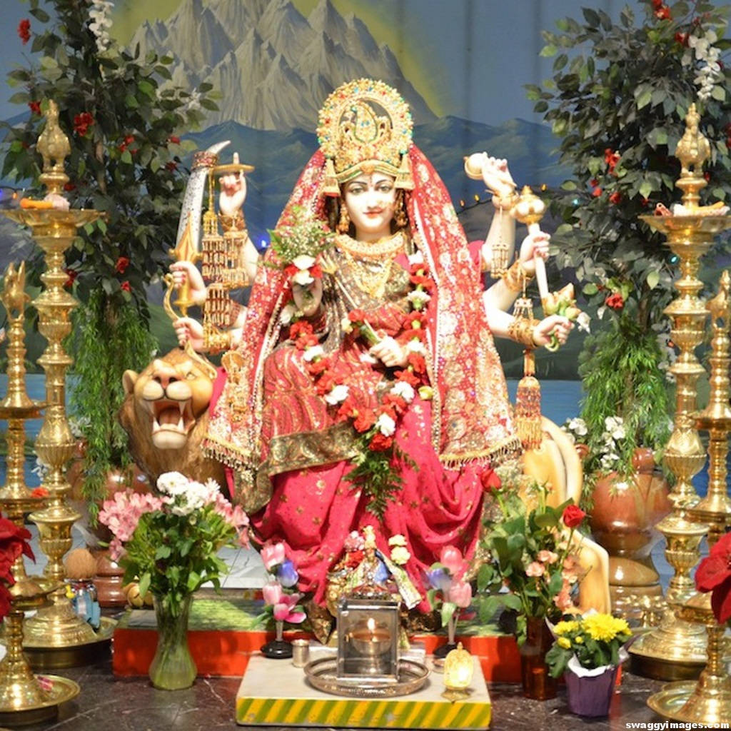 Divine Vaishno Devi Statue Adorned With Fresh Flowers Wallpaper