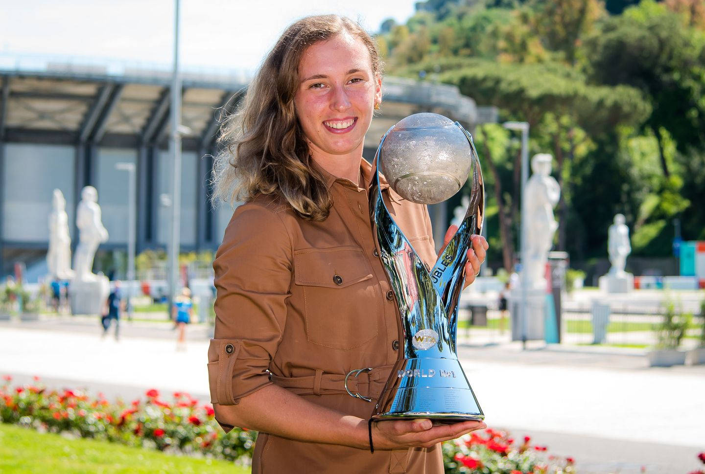 Elise Mertens Holding Tennis Trophy Triumphant Wallpaper