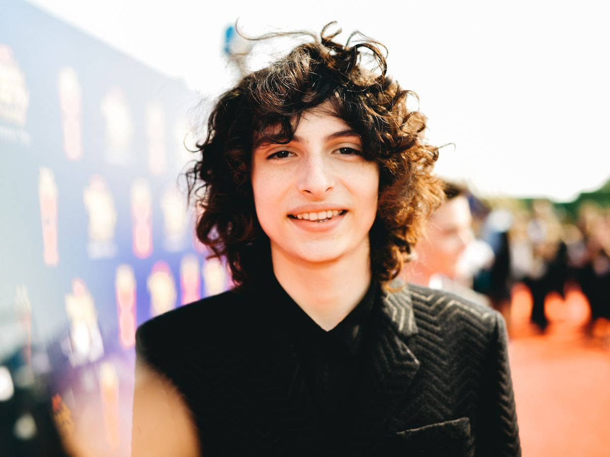 Finn Wolfhard With Wavy Hair Wallpaper