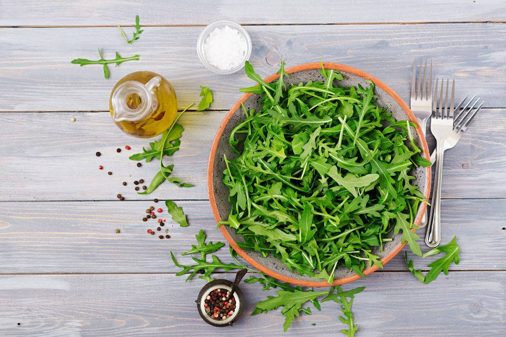 Fresh Arugula Salad Tossed In Olive Oil And Sauce Wallpaper