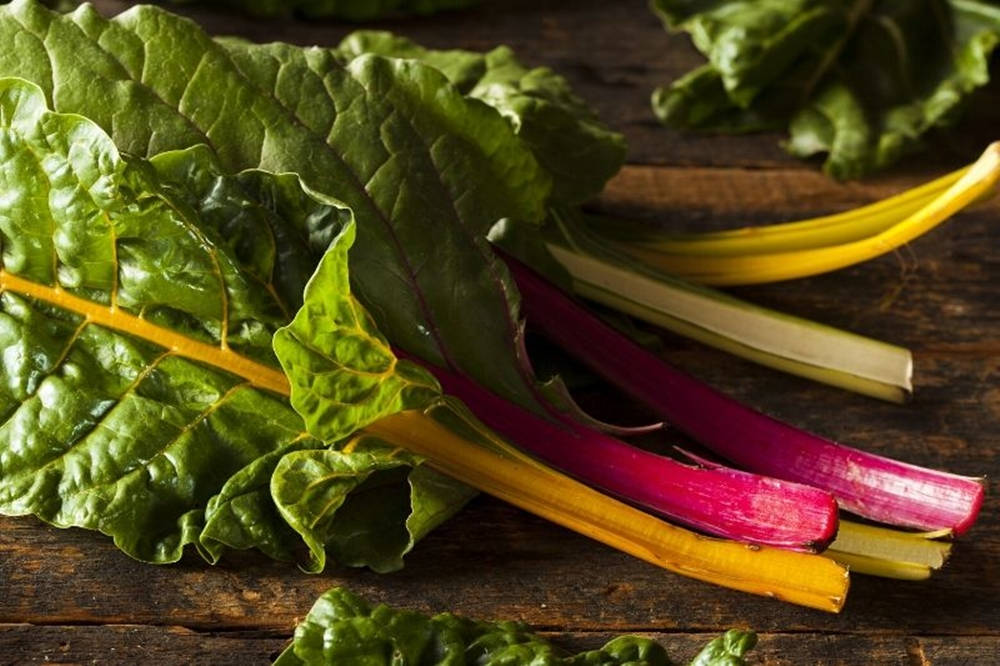 Fresh Swiss Chard On Rustic Wooden Table Wallpaper