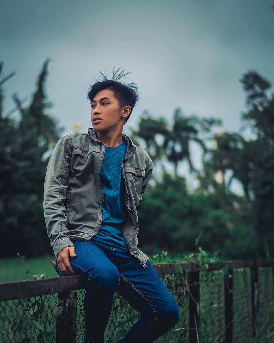 Guy In A Jacket Sitting On A Fence Wallpaper