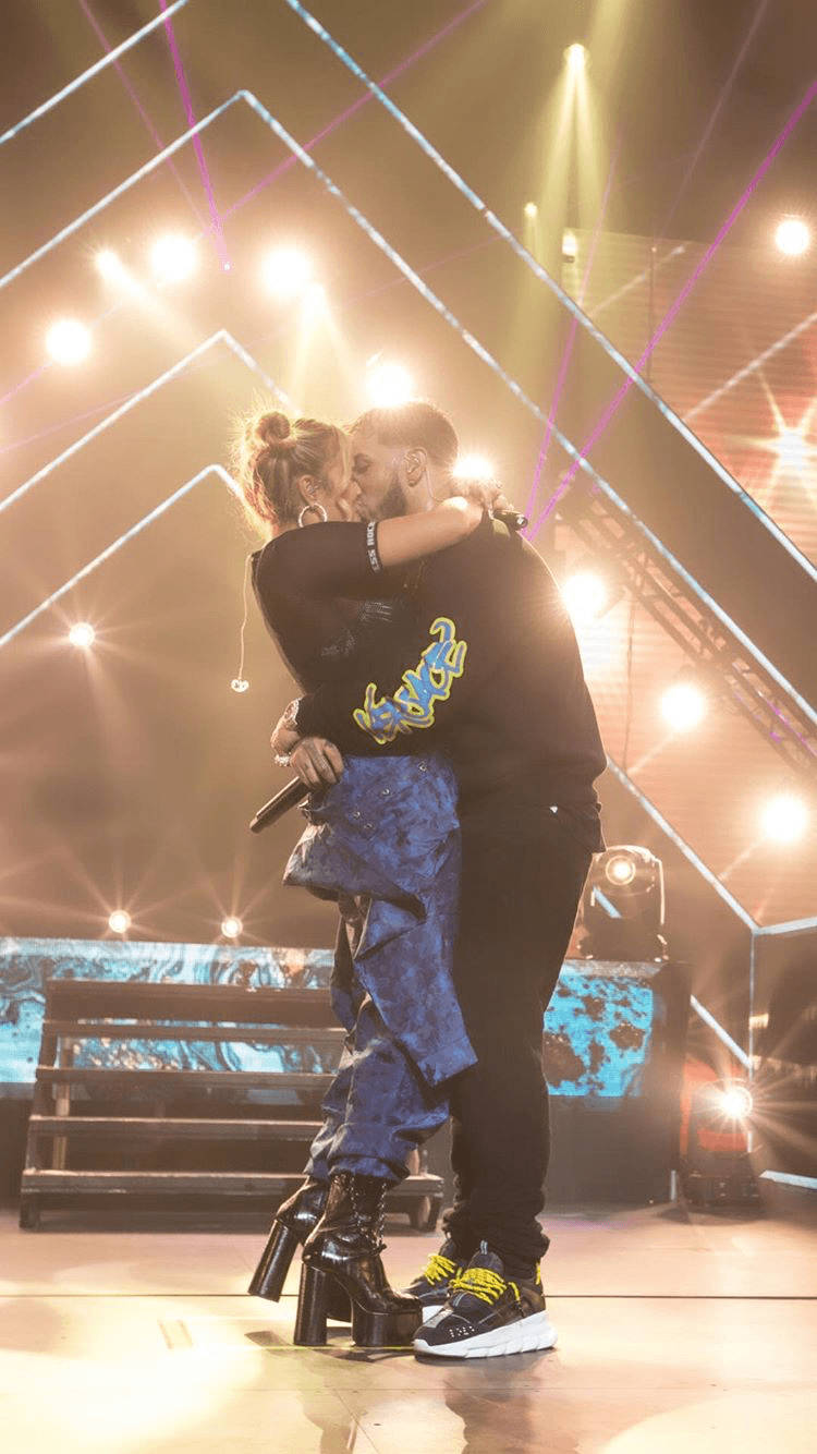 Karol G Kissing On Stage Wallpaper