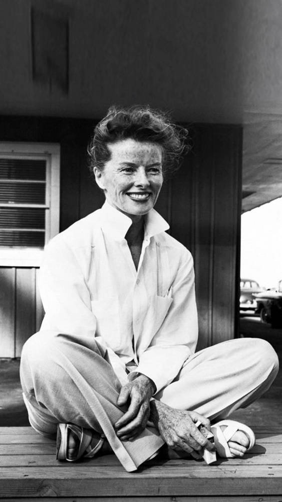 Katharine Hepburn Seated On A Wooden Floor Wallpaper