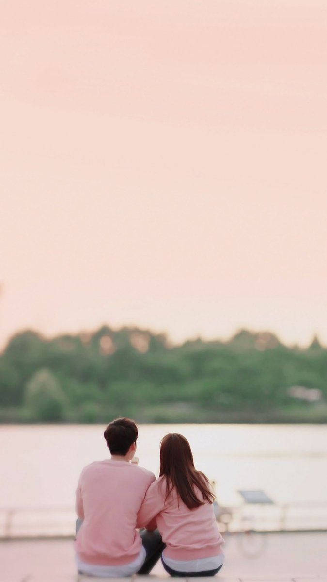 Korean Couple Sitting Back In Pink Wallpaper