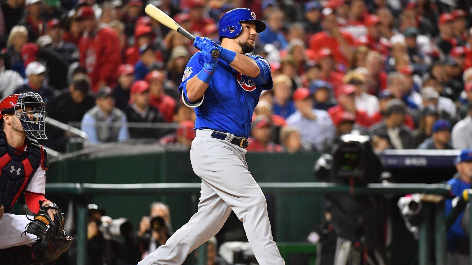 Kyle Schwarber Swinging In Blue Wallpaper