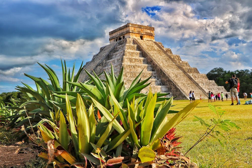 Majestic View Of Ancient Chichen Itza Pyramid Surrounded By Lush Foliage Wallpaper