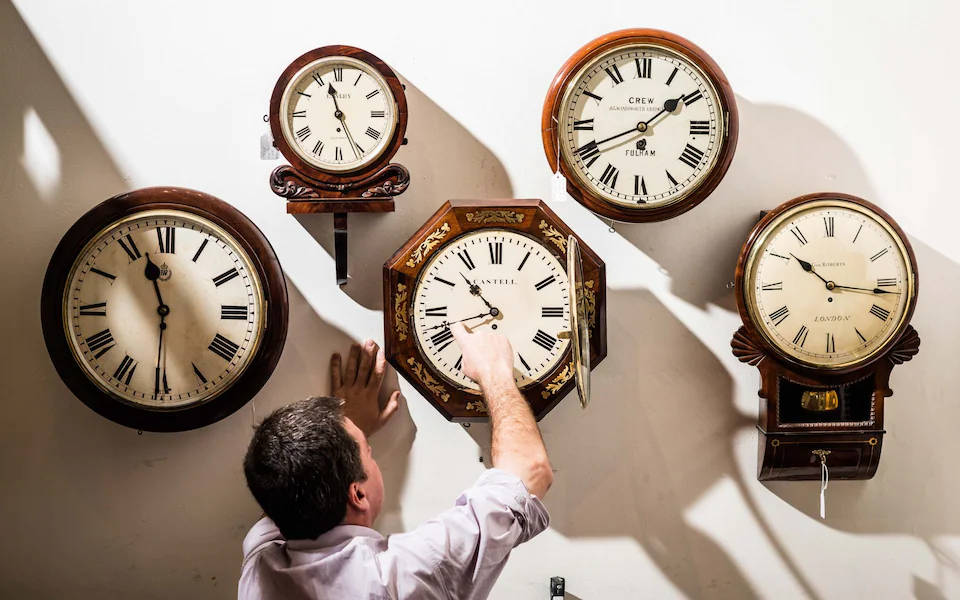 Man Gazing At Roman Numeral Clocks Wallpaper