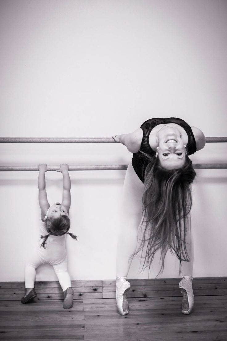 Mother Helping Her Daughter Workout At The Ballet Barre Wallpaper