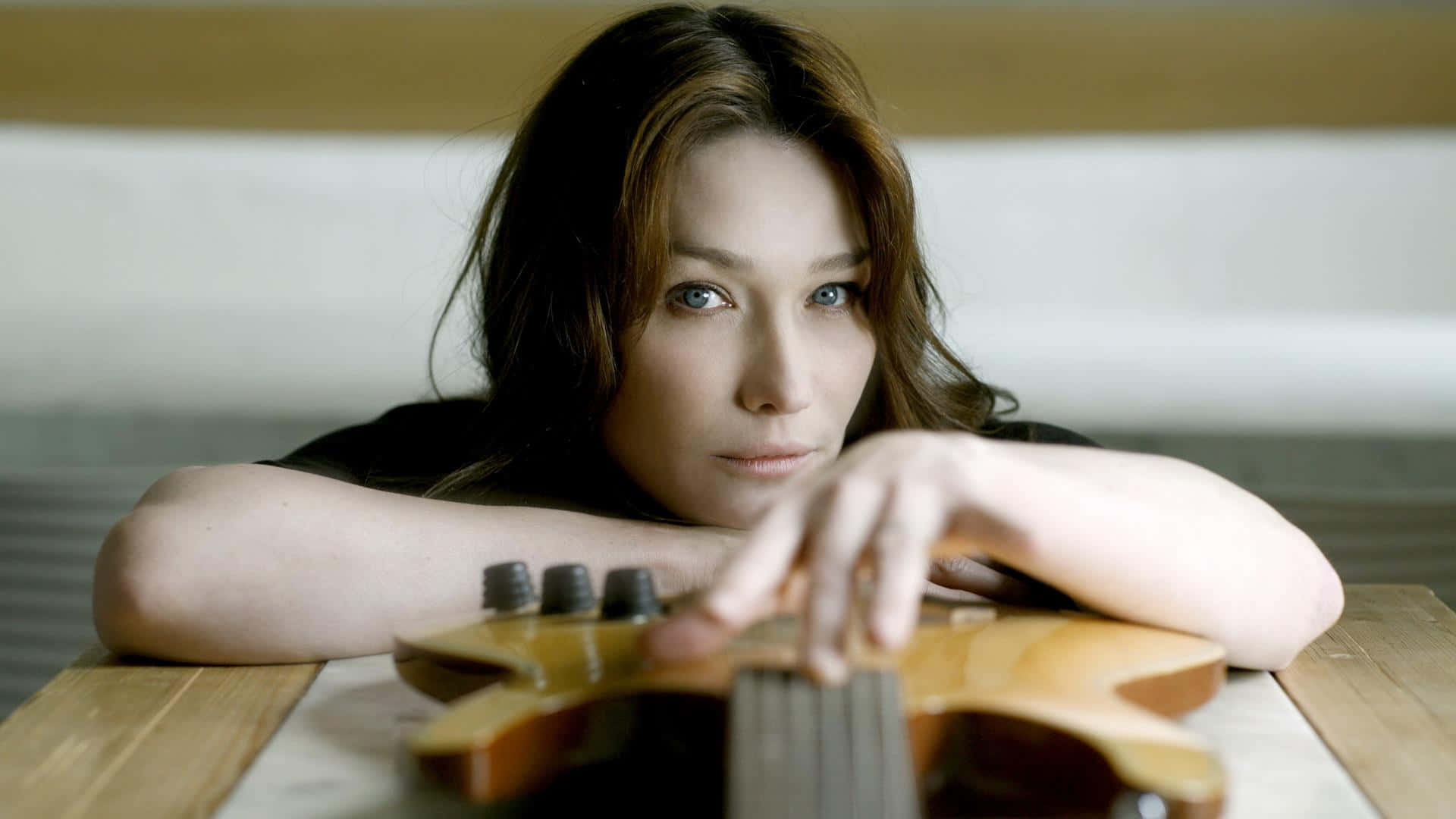 Pop Icon Carla Bruni Strumming Her Guitar Wallpaper