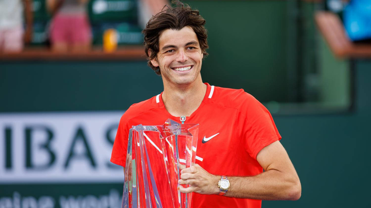 Professional Tennis Player Taylor Fritz Lifting The Tennis Tournament Trophy Wallpaper