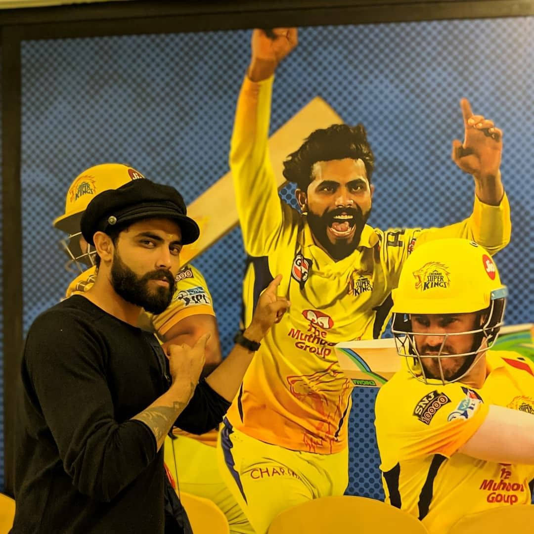 Ravindra Jadeja Posing In Front Of A Poster Wallpaper