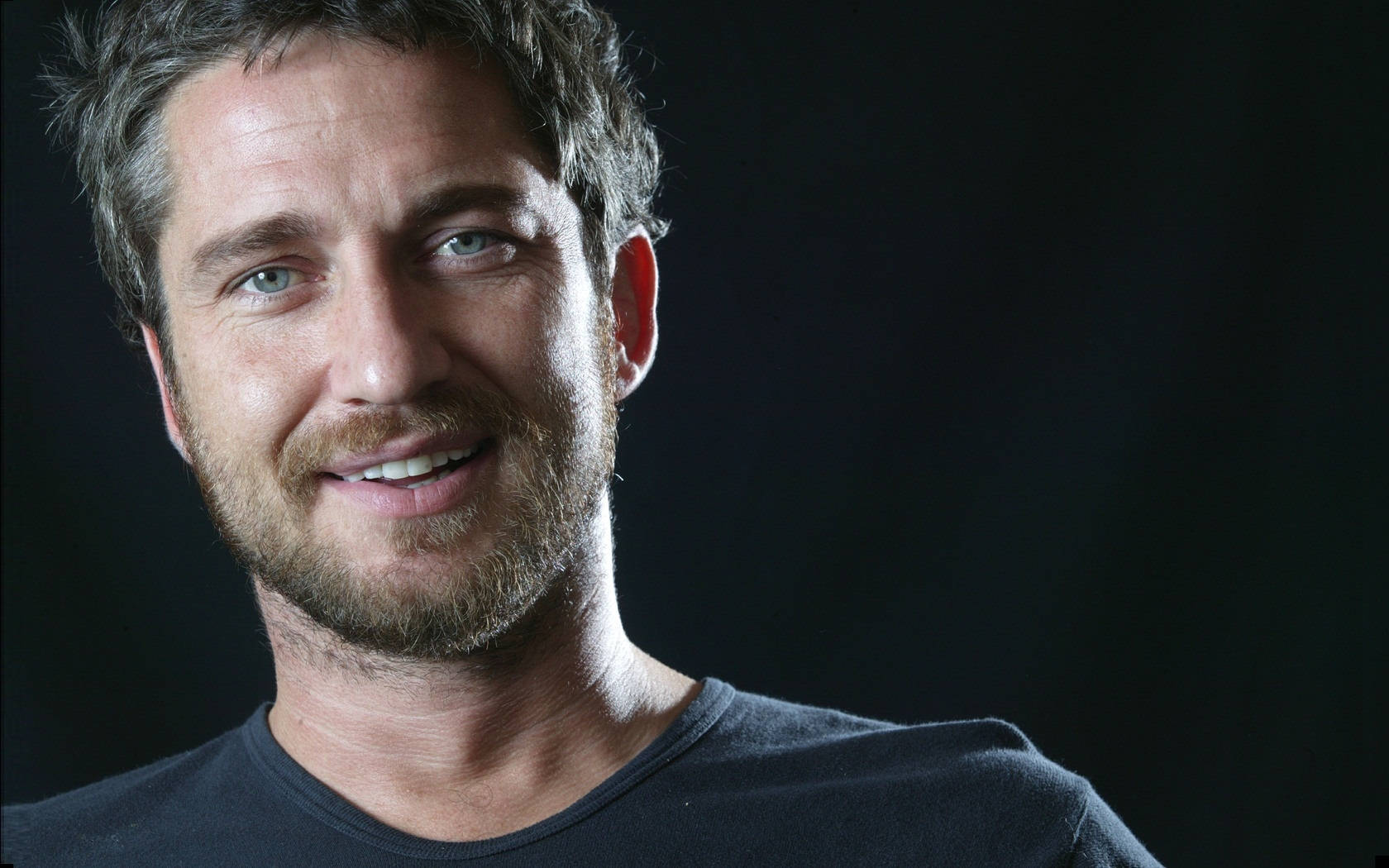 Scottish Actor Gerard Butler Flashing A Warm Smile Wallpaper