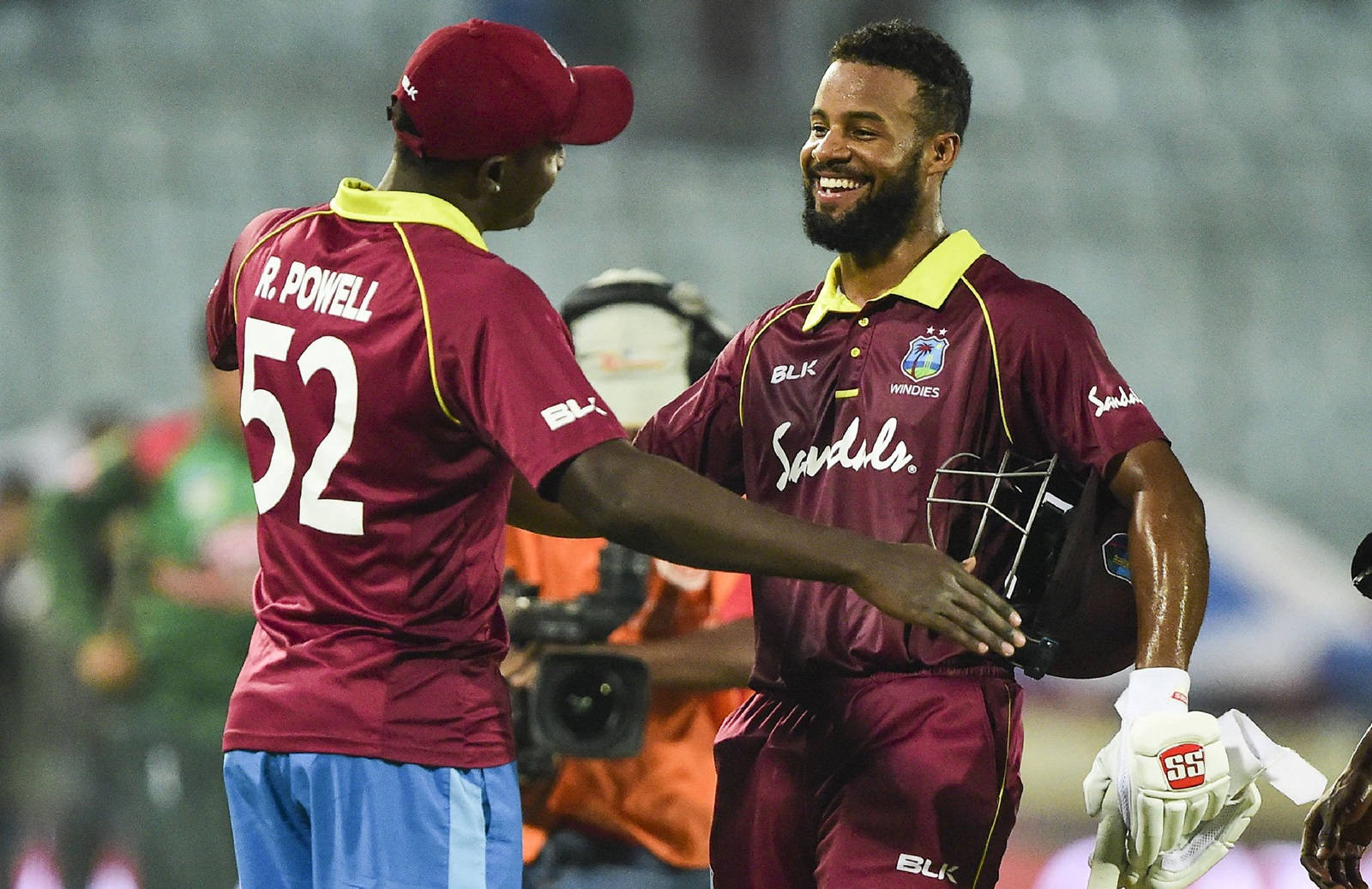 Shai Hope Embracing A Teammate In A Friendly Hug Wallpaper