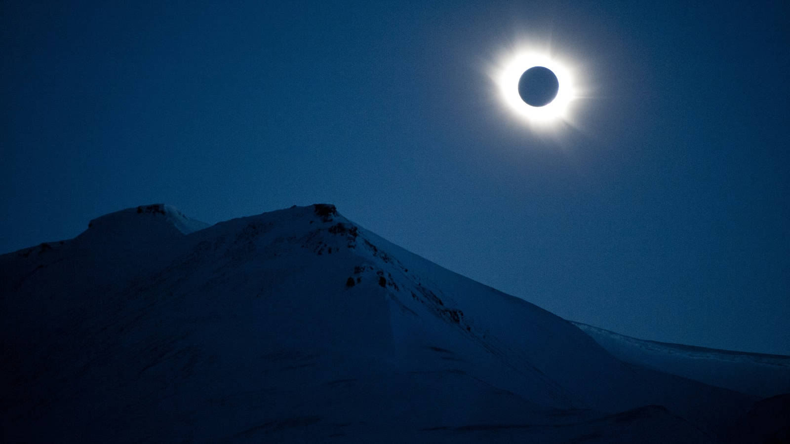 Solar Eclipse Over Snow-capped Mountain Wallpaper