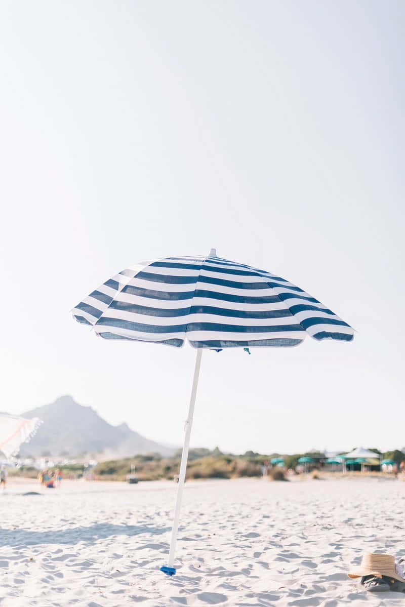 Striped Beach Umbrella Sandy Shoreline Wallpaper