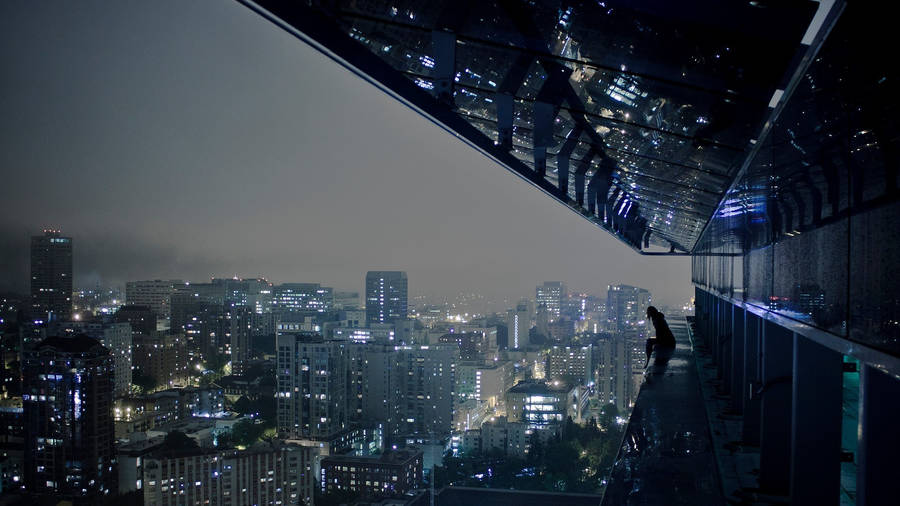 1920 X 1080 Night City Woman Sitting On A Building Edge Wallpaper
