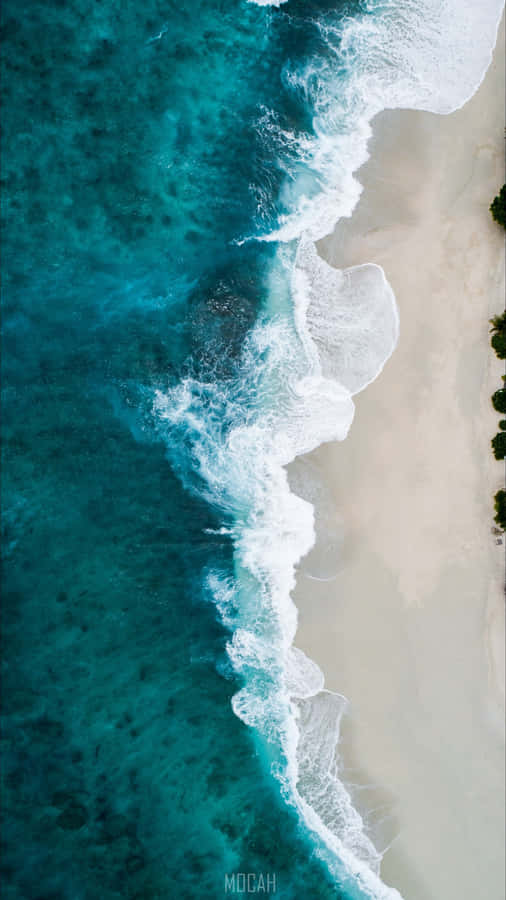 A Beach With Waves And Sand Wallpaper