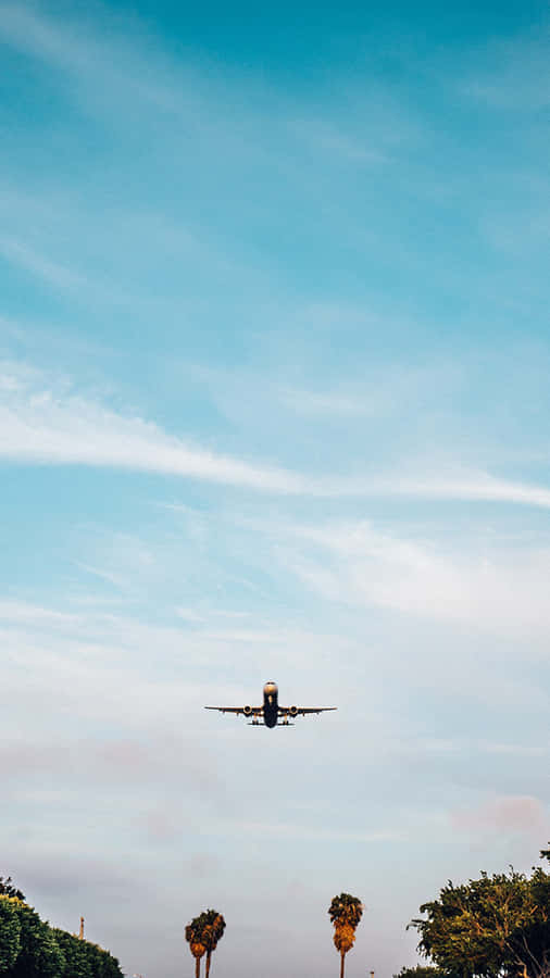 A Beautiful Aerial Shot Of A Plane Soaring Through The Sky Wallpaper