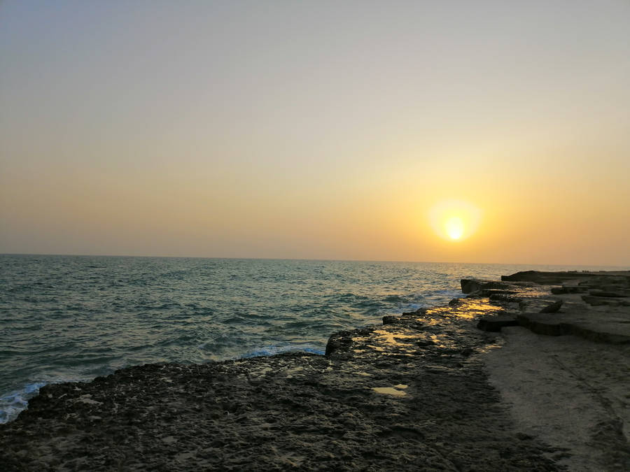 A Beautiful Sunset At A Rocky Beach. Wallpaper