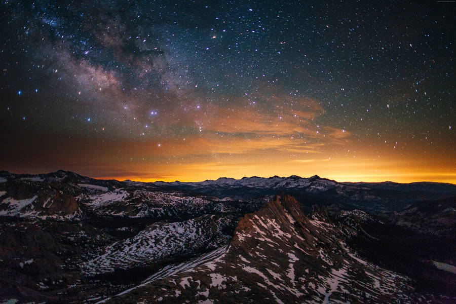A Blanket Of Stars Above A Peaceful Orange And Pink Horizon Wallpaper