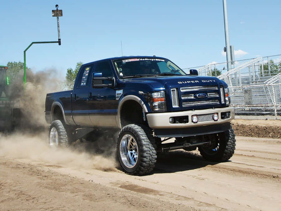 A Blue Truck Driving On Dirt Wallpaper