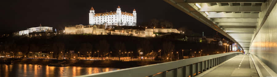 A Bridge Over A River With A Castle In The Background Wallpaper