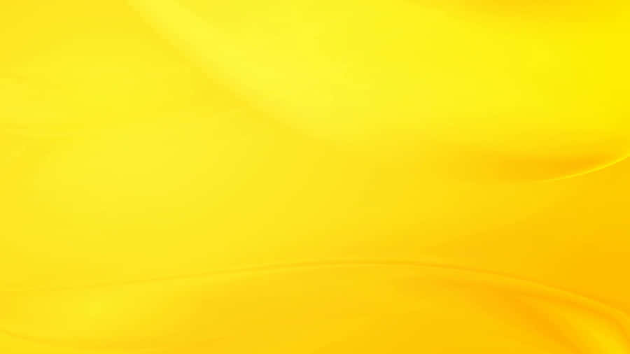 A Bright, Pastel Yellow Laptop Resting On A Wooden Desk Wallpaper