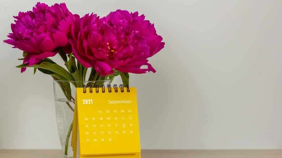 A Calendar With Flowers In A Vase Wallpaper