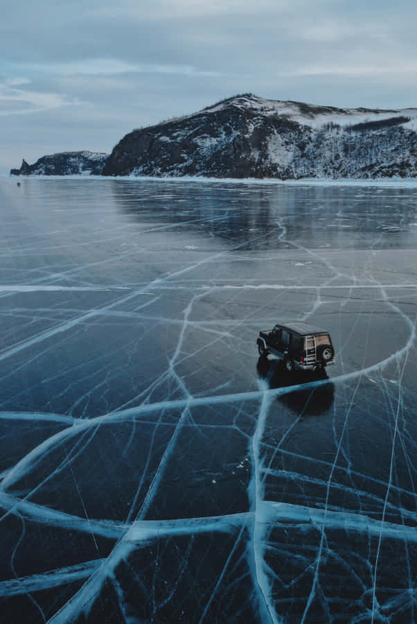 A Car Driving Over The Beautifully Frozen Expanses Of Lake Baikal Wallpaper