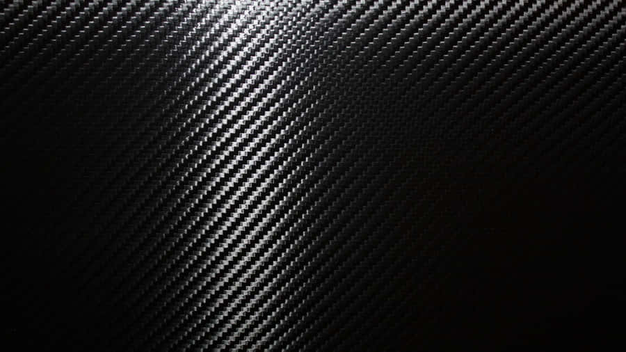 A Close-up View Of Black Carbon Fiber In A Luxurious Pattern Wallpaper