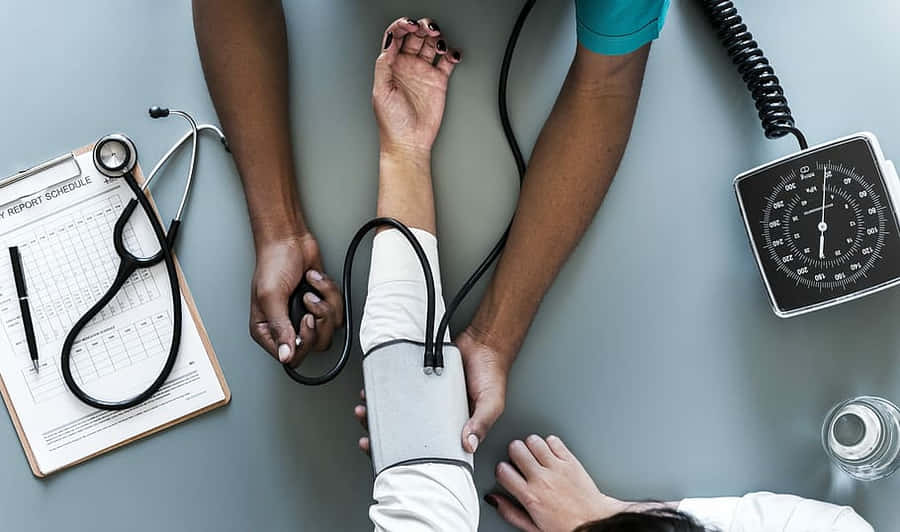 A Doctor Is Taking A Patient's Blood Pressure Wallpaper