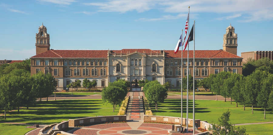 A Large Building With A Flag Flying In Front Of It Wallpaper