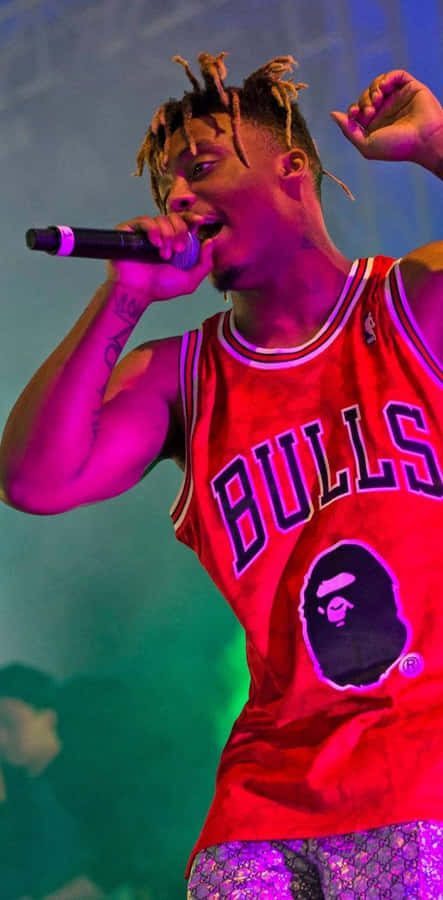 A Man In A Chicago Bulls Jersey Singing Into A Microphone Wallpaper