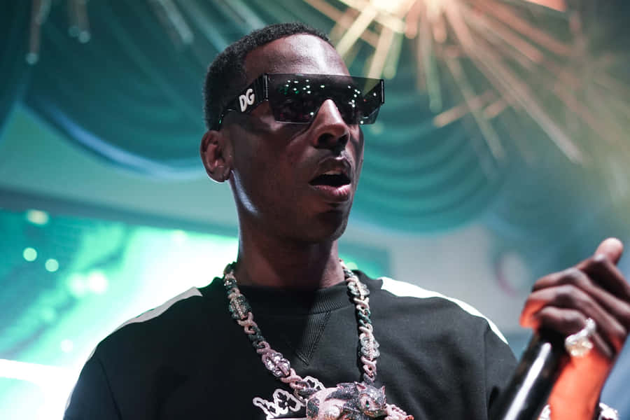 A Man In Sunglasses Is Holding A Microphone Wallpaper