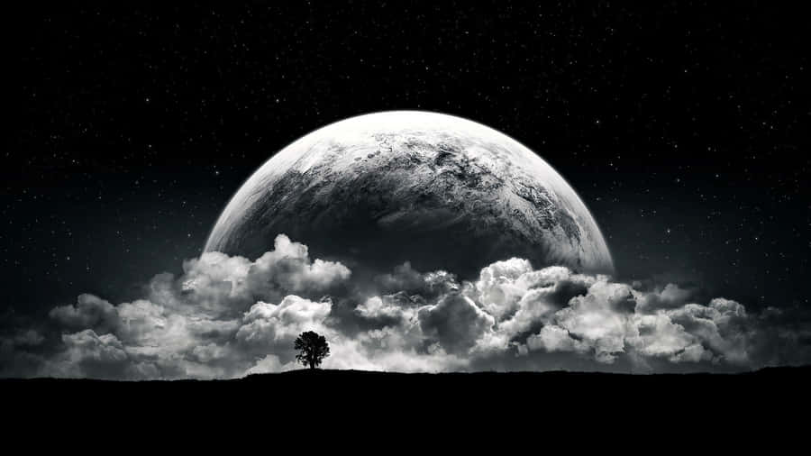 A Man Is Standing On A Hill With A Moon In The Background Wallpaper