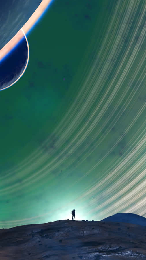 A Man Is Standing On A Hill With Two Planets In The Background Wallpaper