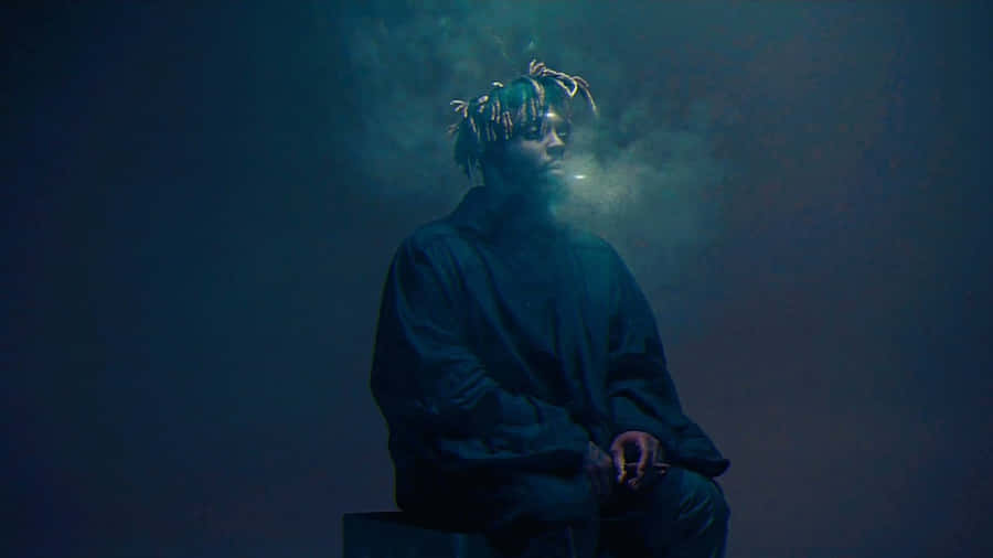 A Man Sitting On A Box With Smoke Coming Out Of His Mouth Wallpaper