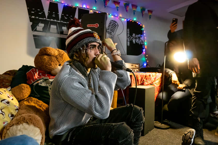 A Man Sitting On A Couch With A Teddy Bear Wallpaper