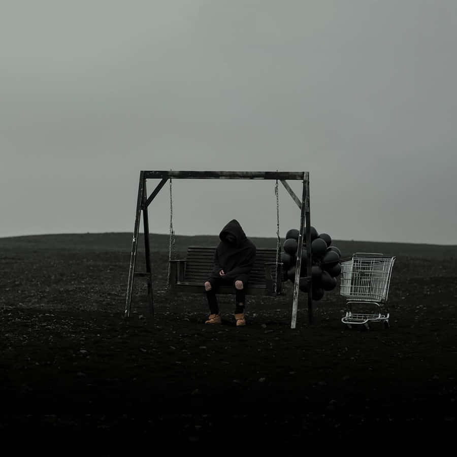 A Man Sitting On A Swing In A Field With Balloons Wallpaper