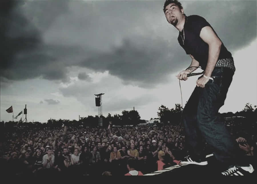 A Man Standing On Stage With A Microphone Wallpaper