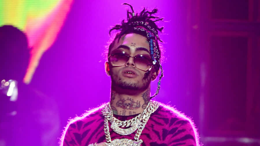 A Man With Dreadlocks And A Necklace On Stage Wallpaper