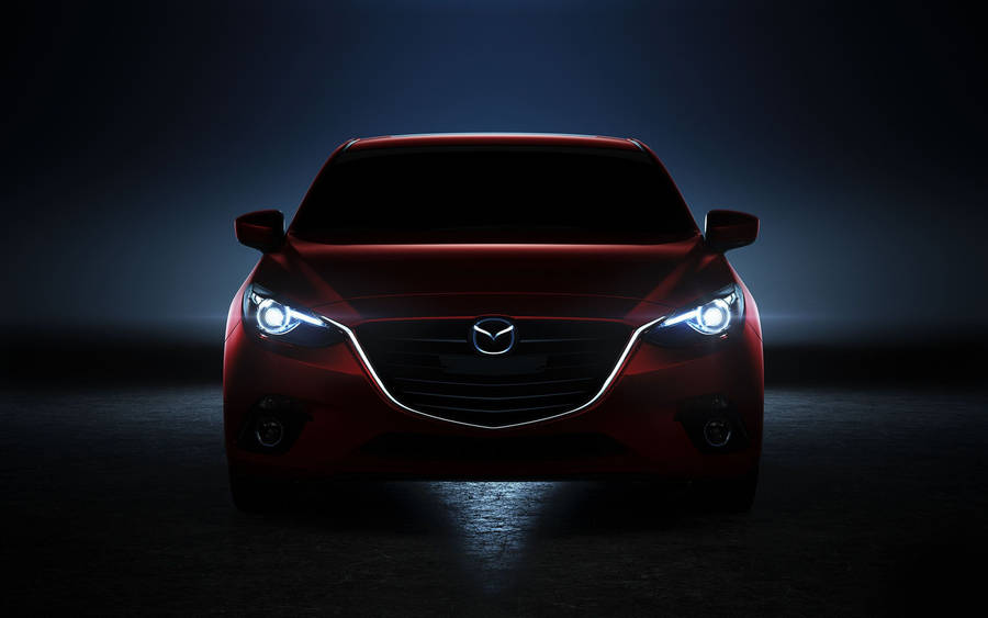 A Neon Red Mazda 2 Illuminated In Nightfall Wallpaper