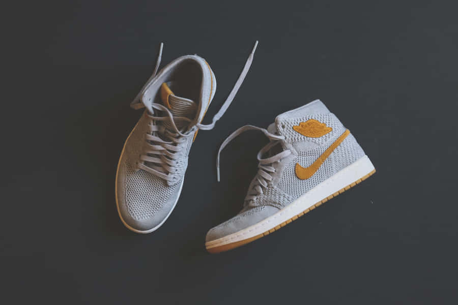 A Pair Of Air Jordan 1 High Sneakers On A Black Surface Wallpaper